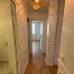 Couloir rénové avec lampe élégante et sol poli